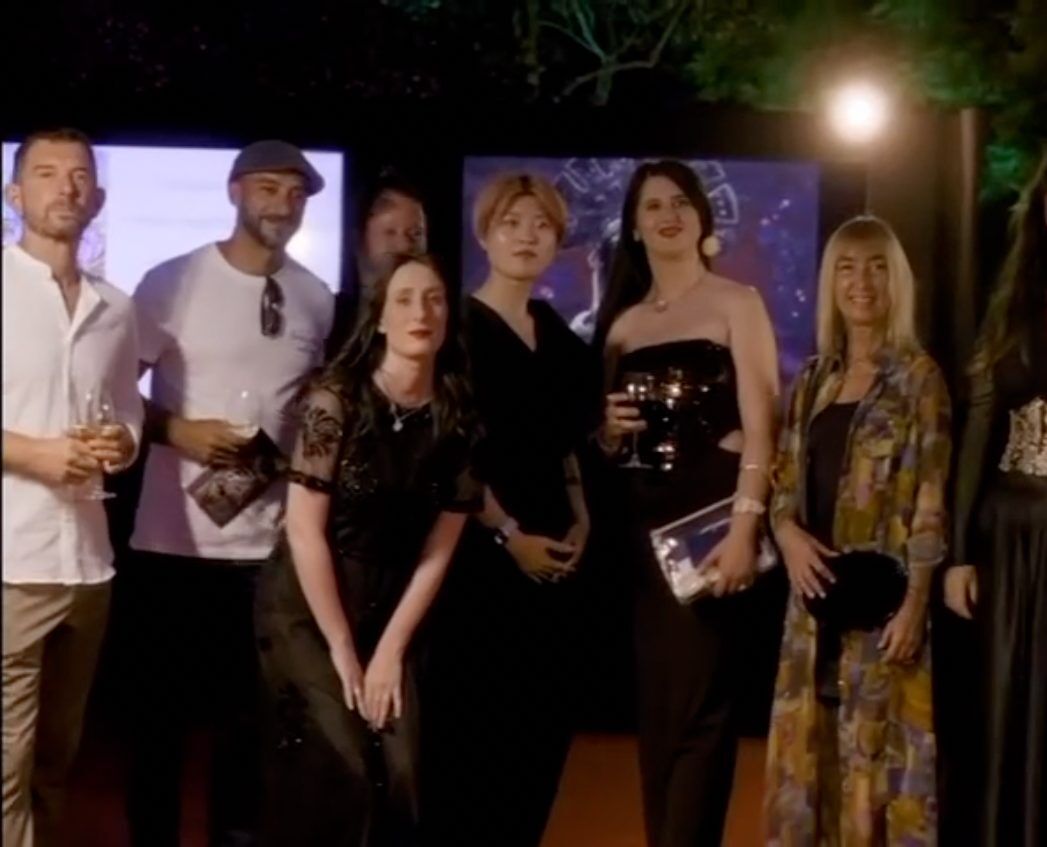 Grupo de artistas y asistentes en la exhibición nocturna