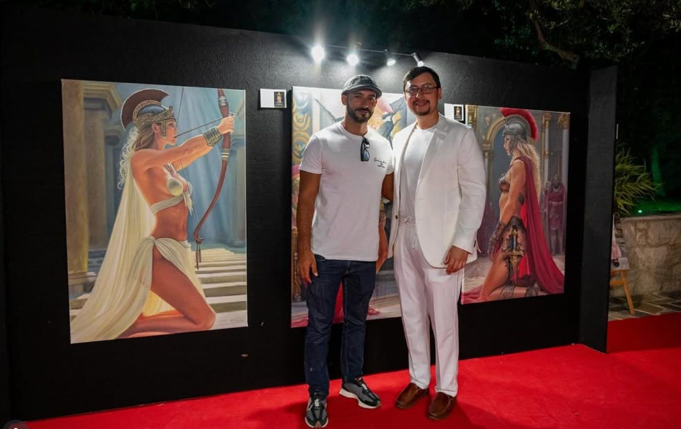Dos asistentes frente a dos pinturas figurativas en la exhibición nocturna